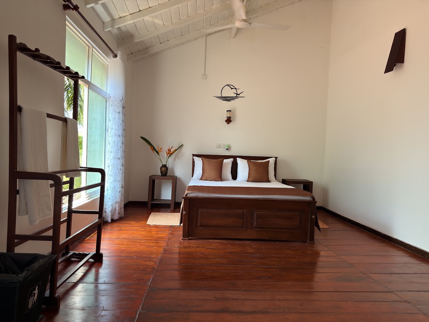 Spacious bedroom with high white ceiling and dark timber furniture