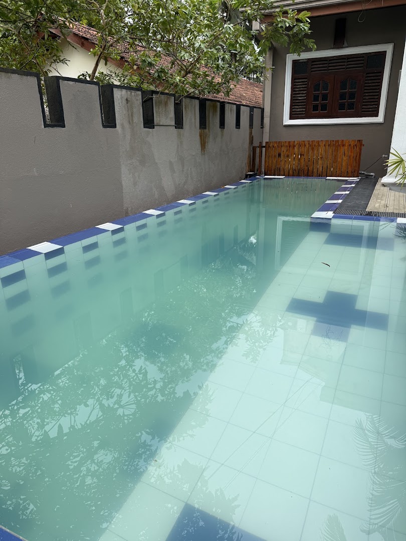 Long blue-tiled swimming pool beside the villa