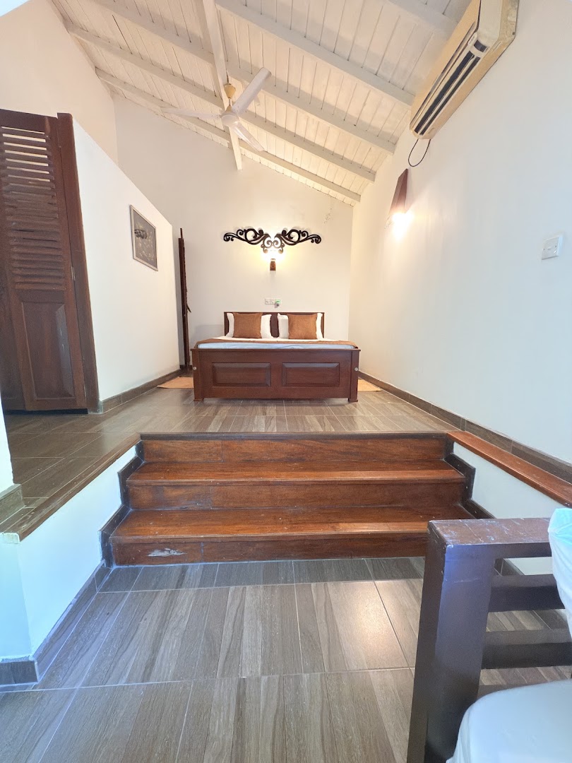 Bedroom with a pitched white ceiling and dark timber steps